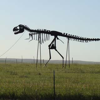 Statue of Man Walking Dino